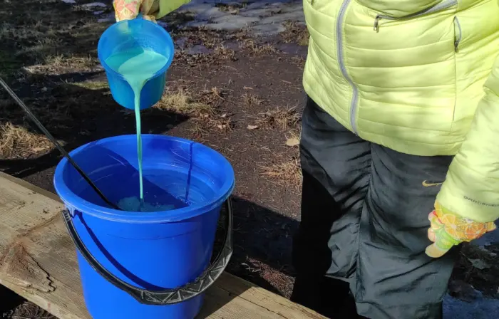 садовник разводит препарат в ведре